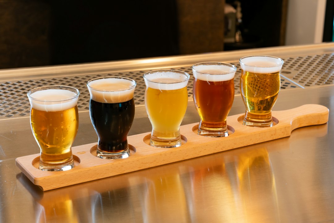 Row of craft beer glasses on a wooden tray, illustrative photograph